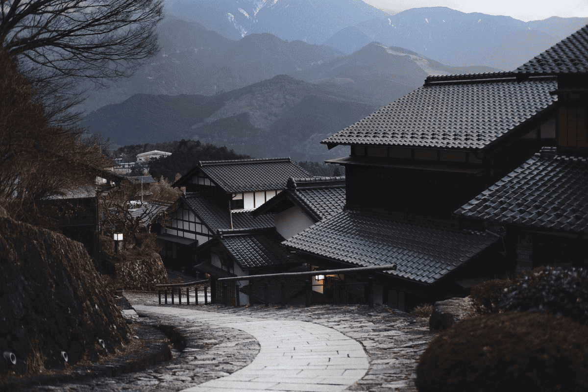 Quiet mountain village with tiled roofs and a winding stone footpath.